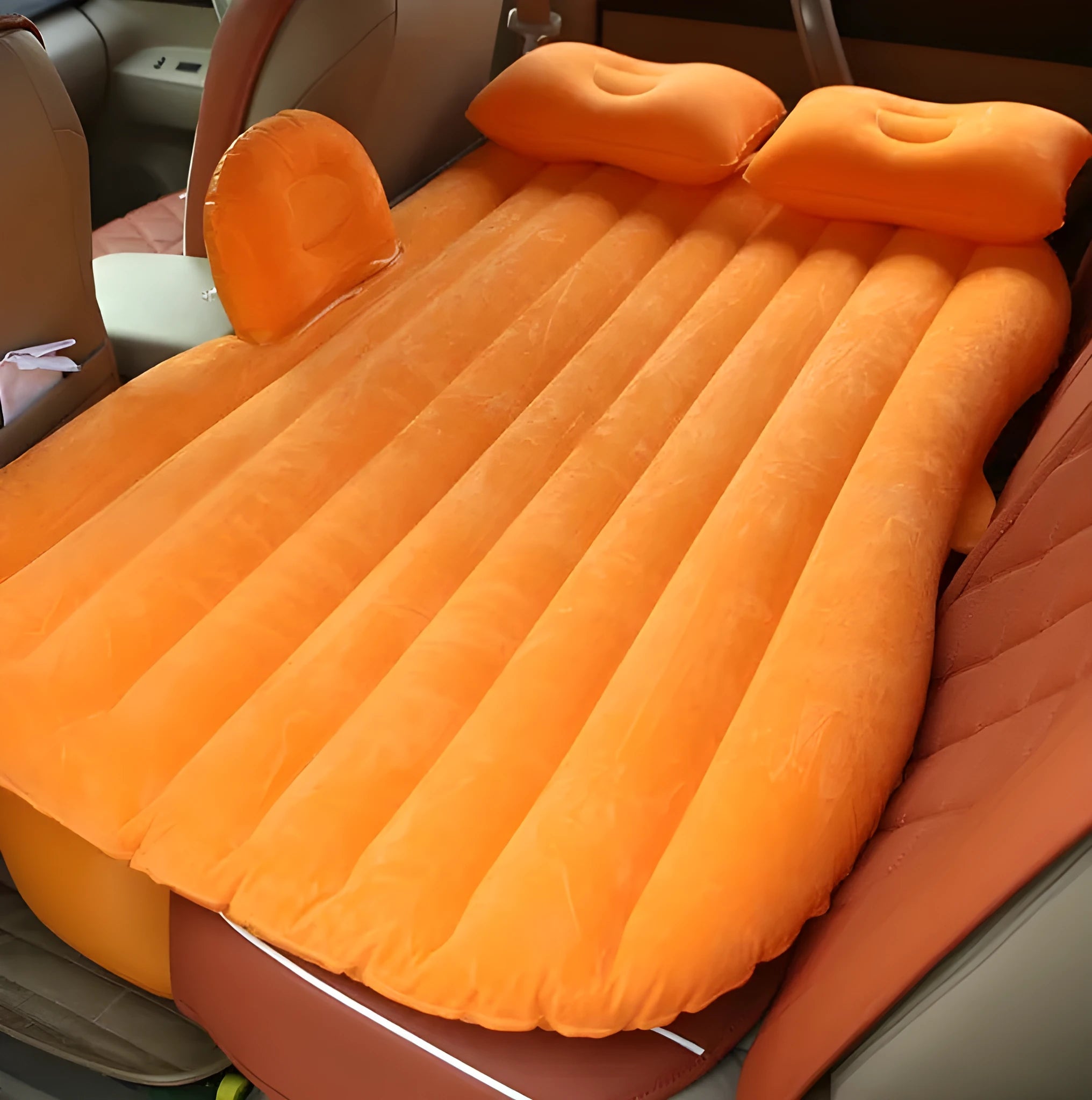 Black inflatable car bed with flocking surface and two pillows, shown folded next to a storage bag.