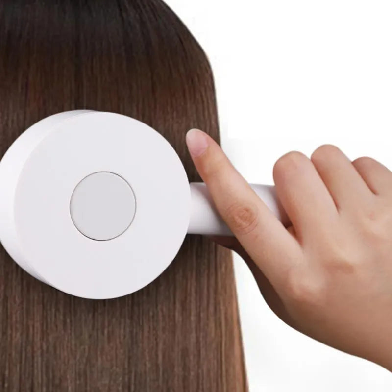 One-key self-cleaning hair brush with green airbag massage comb and non-slip handle on white background