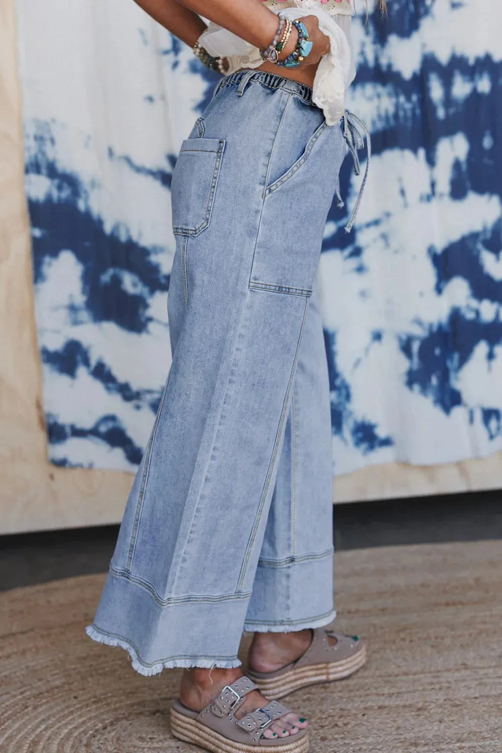 Beau blue women's wide leg denim trousers with drawstring waist and raw hem detail.