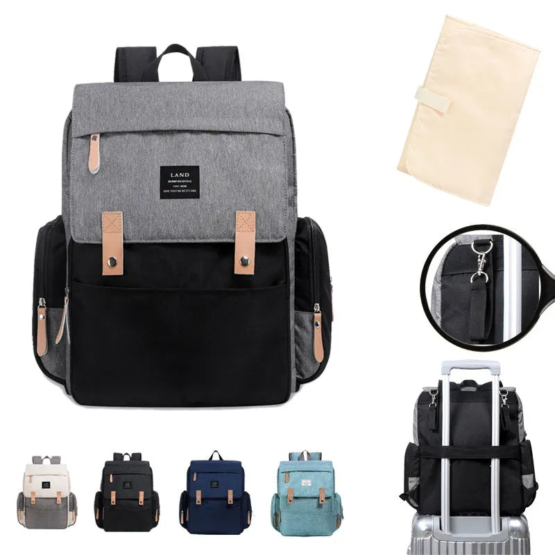 LAND Mommy large grey diaper backpack with changing mat, shown with baby care items.