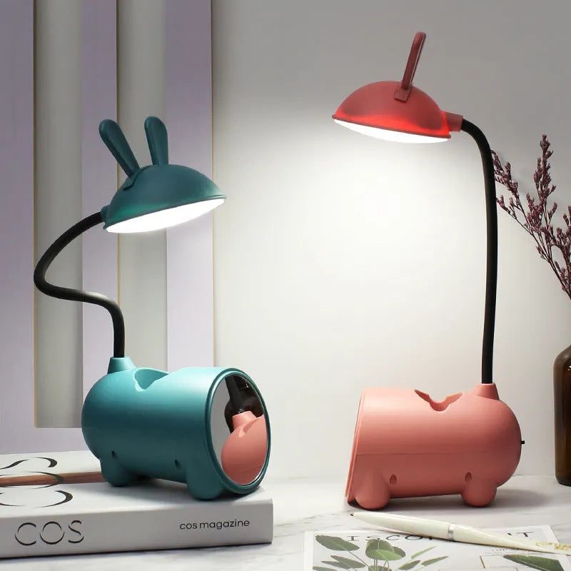 Green cartoon-themed USB table lamp with pen container base on desk