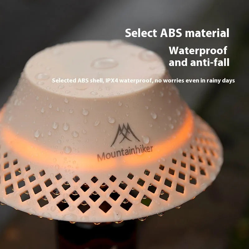 Beige wine bottle shaped rechargeable camping lantern with LED light on a wooden surface.