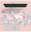 Large floral cartoon pattern mouse pad on a desk, showing non-slip rubber base and colourful design.