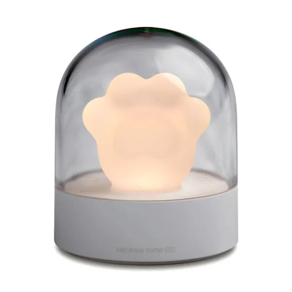 Pink and grey cat paw shaped USB night light with a music box feature on a desktop.