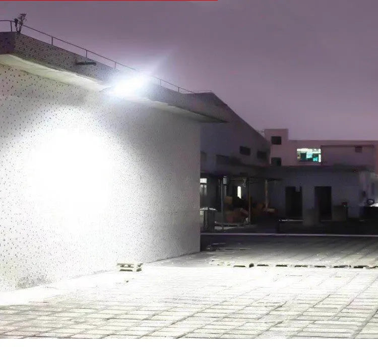 Black outdoor solar-powered motion sensor security light mounted on a wall.