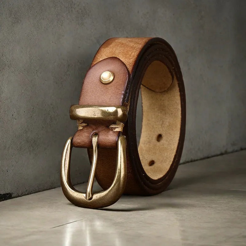 Men's brown casual leather belt with copper pin buckle on a jeans background.