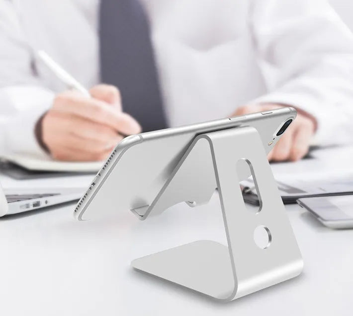 Aluminium phone stand in choice of black, red, rose gold, or silver, holding a smartphone.