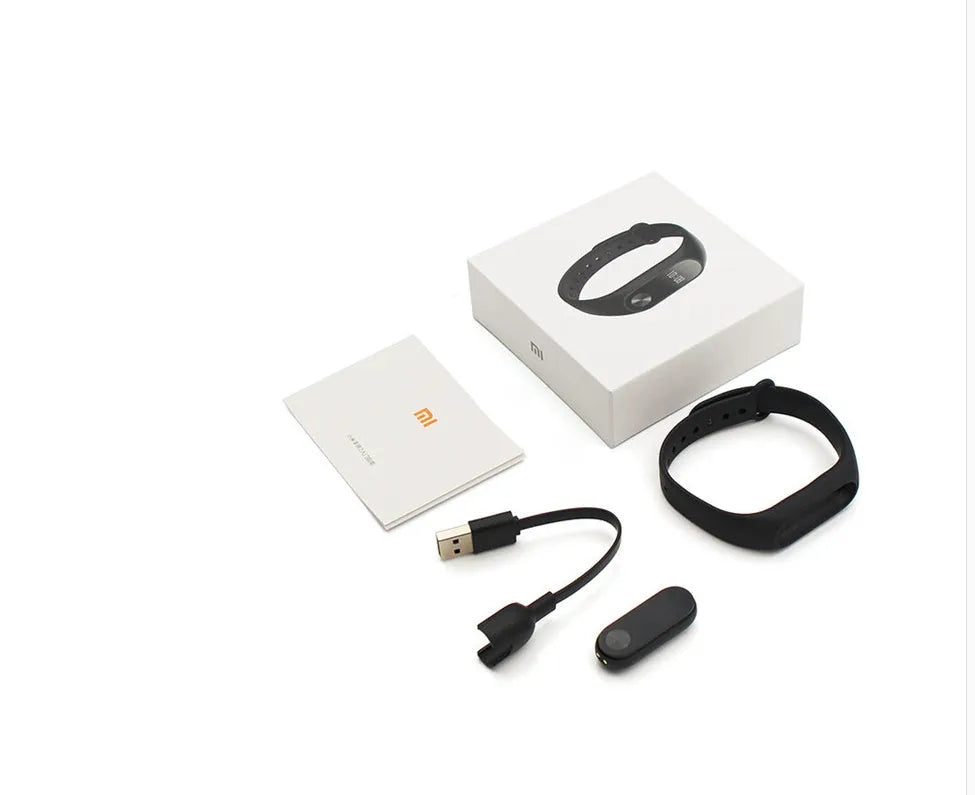 Black Xiaomi Mi Band 2 fitness tracker on wrist showing OLED display with heart rate data.
