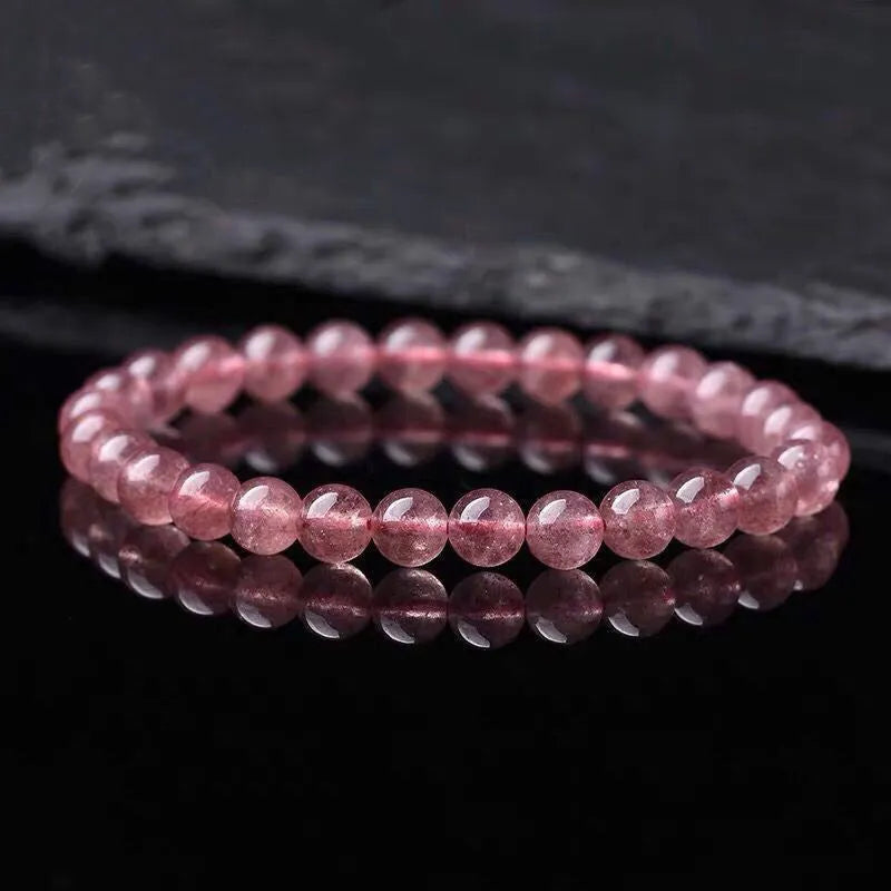 Women's strawberry quartz crystal bracelet showing polished beads in 6mm, 8mm, and 10mm size options