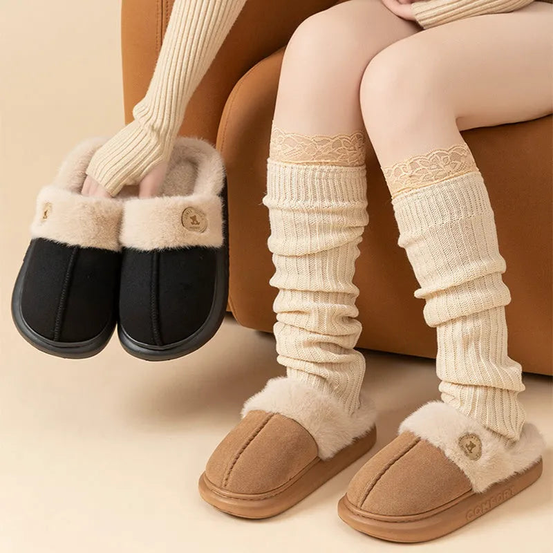 A pair of plush fleece slippers with a thick PVC sole and car stitching detail, shown in a choice of colours.