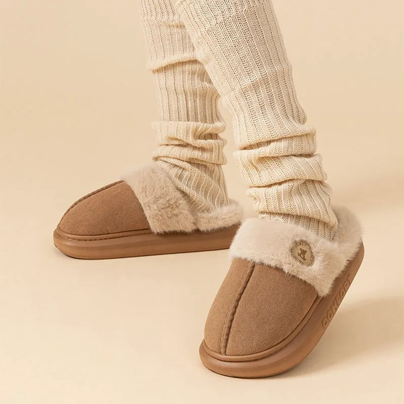 A pair of plush fleece slippers with a thick PVC sole and car stitching detail, shown in a choice of colours.