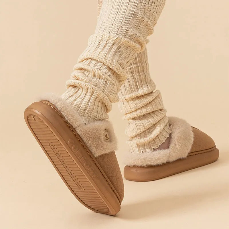 A pair of plush fleece slippers with a thick PVC sole and car stitching detail, shown in a choice of colours.