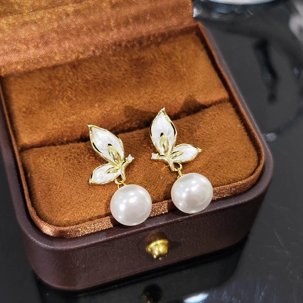 Close-up of zircon painted butterfly stud earrings on copper with electroplated finish