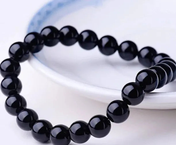 Geometric black agate bead bracelet on elastic cord, showing 8mm bead size.