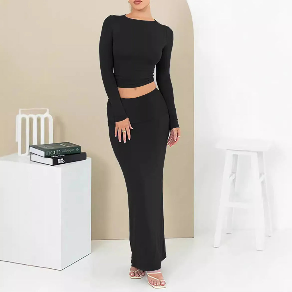 Women's black slim fit two-piece suit set with three-quarter sleeve top and long skirt on a model.