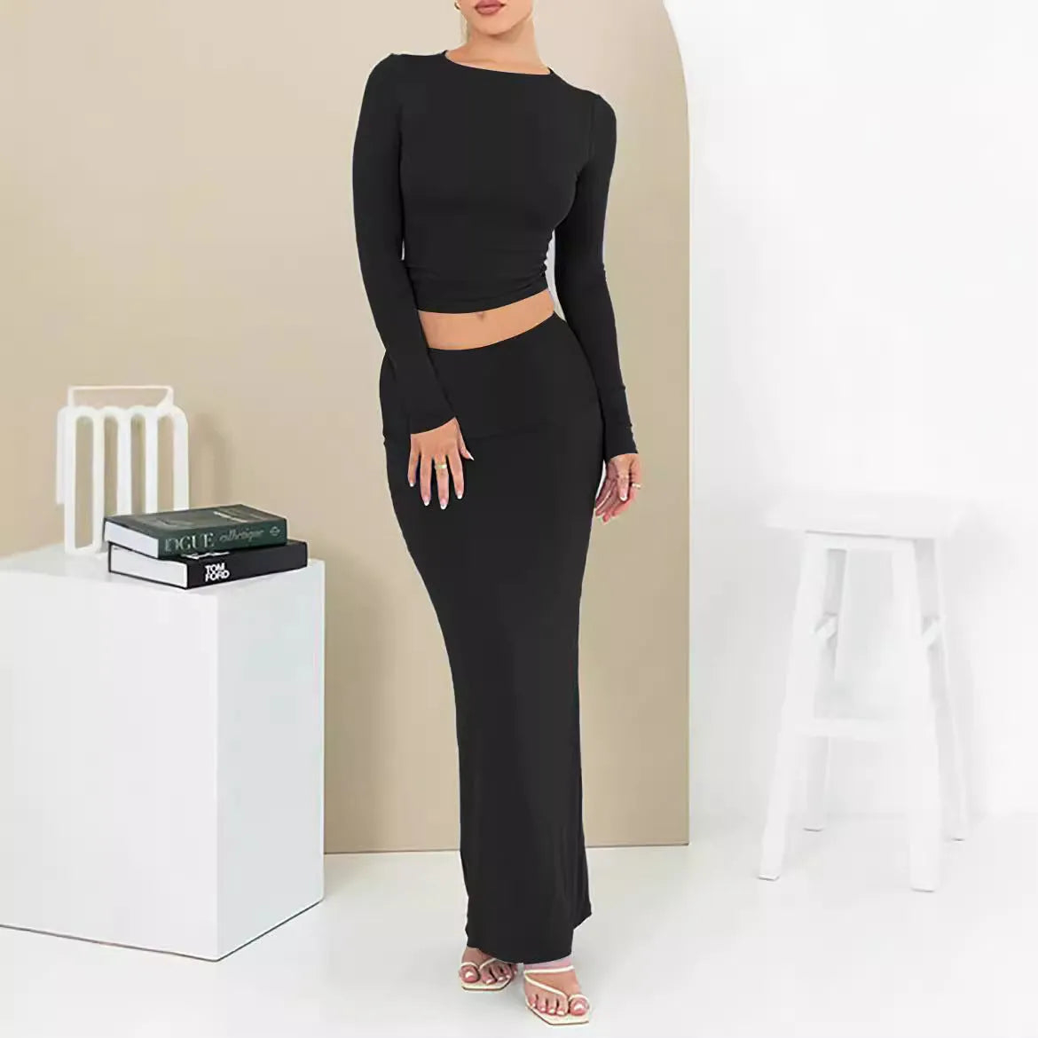 Women's black slim fit two-piece suit set with three-quarter sleeve top and long skirt on a model.