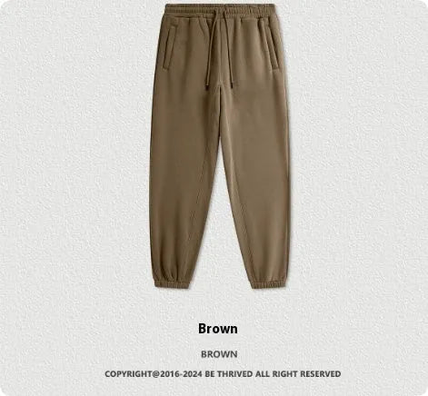 Man wearing dark brown velvet sweatpants with an ankle band and elastic waist.