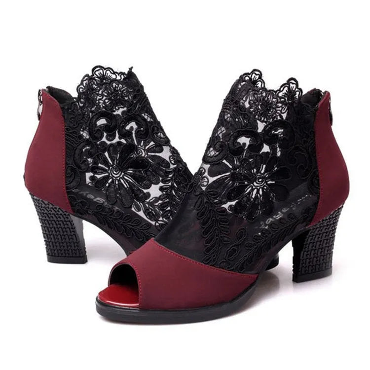 Black women's gladiator sandals with floral lace upper, high square heel, and a front zip closure.