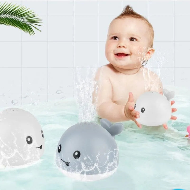Electric whale-shaped baby bath toy with water spray, LED lights, and automatic water sensor
