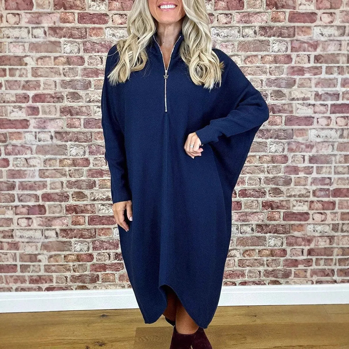 Women's solid colour loose fit knitted dress with raglan sleeves on a model.
