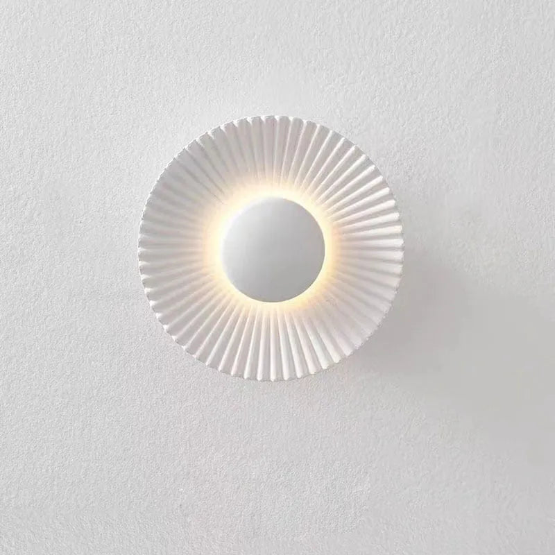 Round aluminium wall lamp mounted on a wall, showing a white and gold two-tone finish.