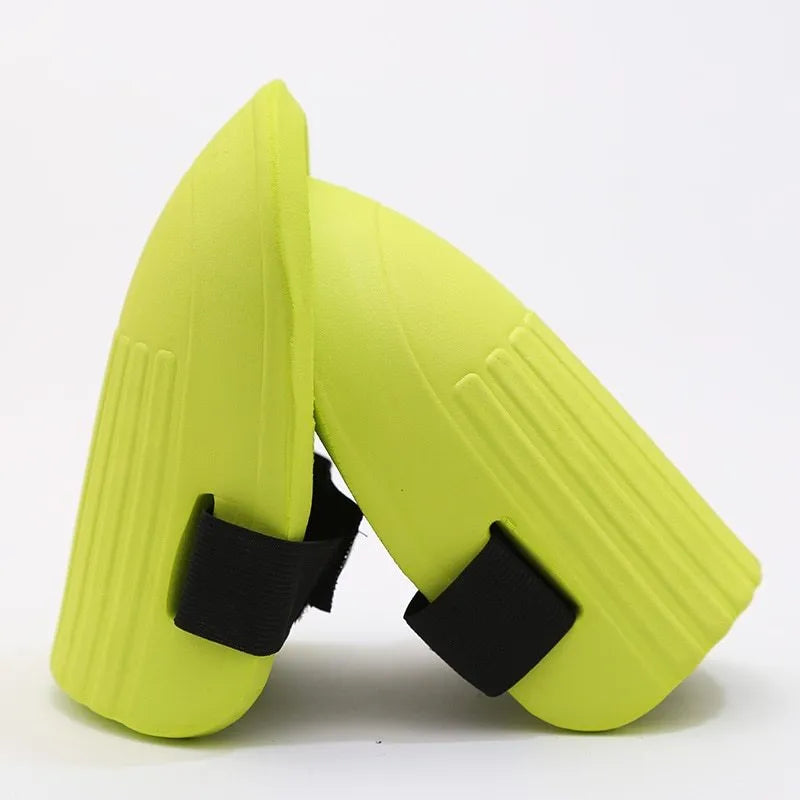 A pair of rectangular EVA foam knee pads in army green colour, shown on a garden soil background.