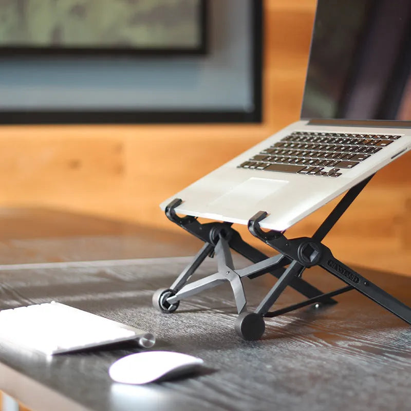 Black folding portable laptop stand made of reinforced nylon, shown folded and unfolded.