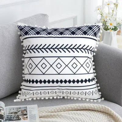 Bohemian patterned pillow cover in light gray on a living room sofa with decorative throw