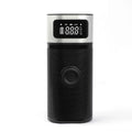 Black portable wireless smart air pump with display, charging cable and nozzle attachments on a dark surface.