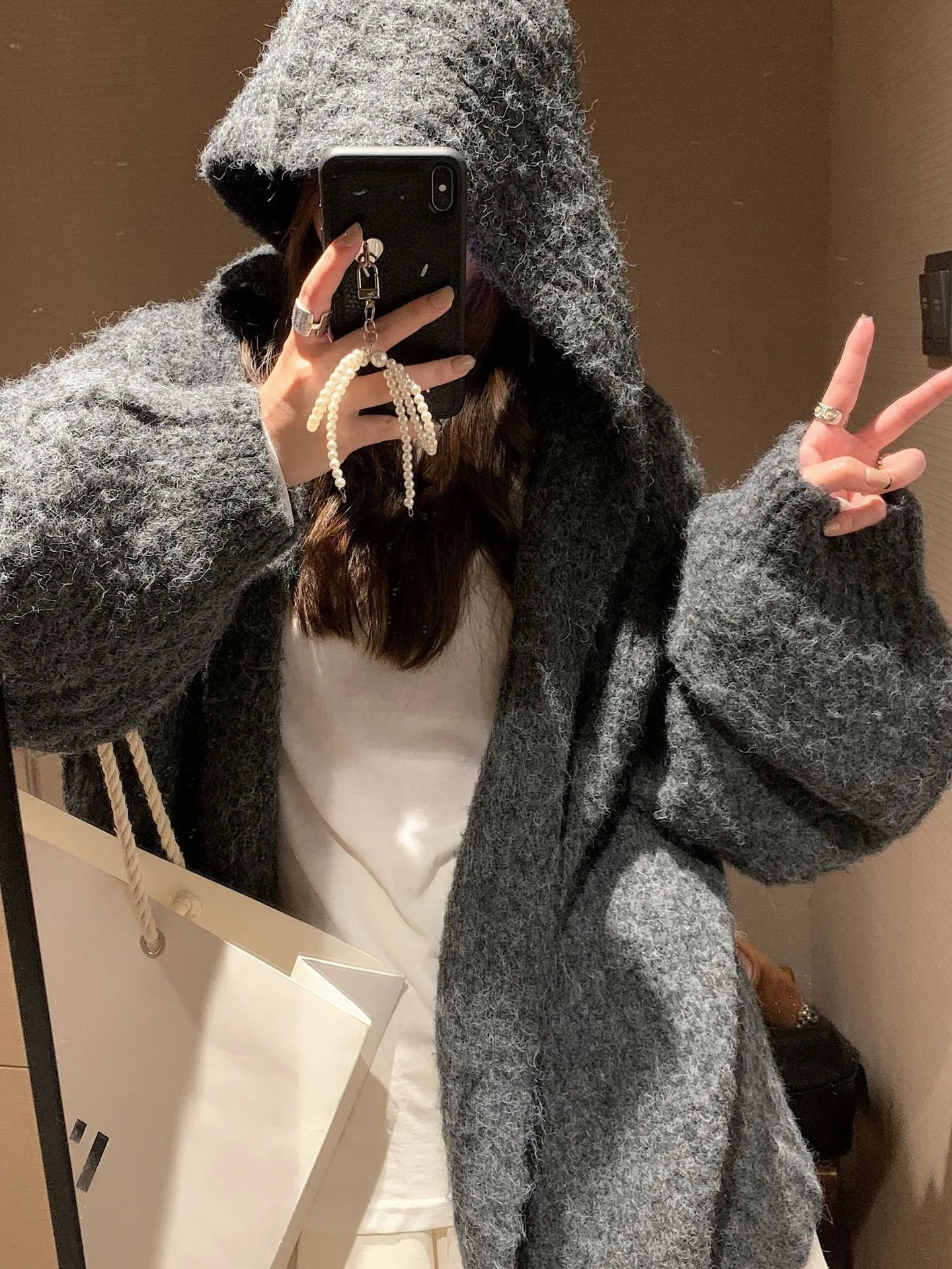 A woman's dark grey hooded cardigan with long sleeves, shown open in a loose fit.