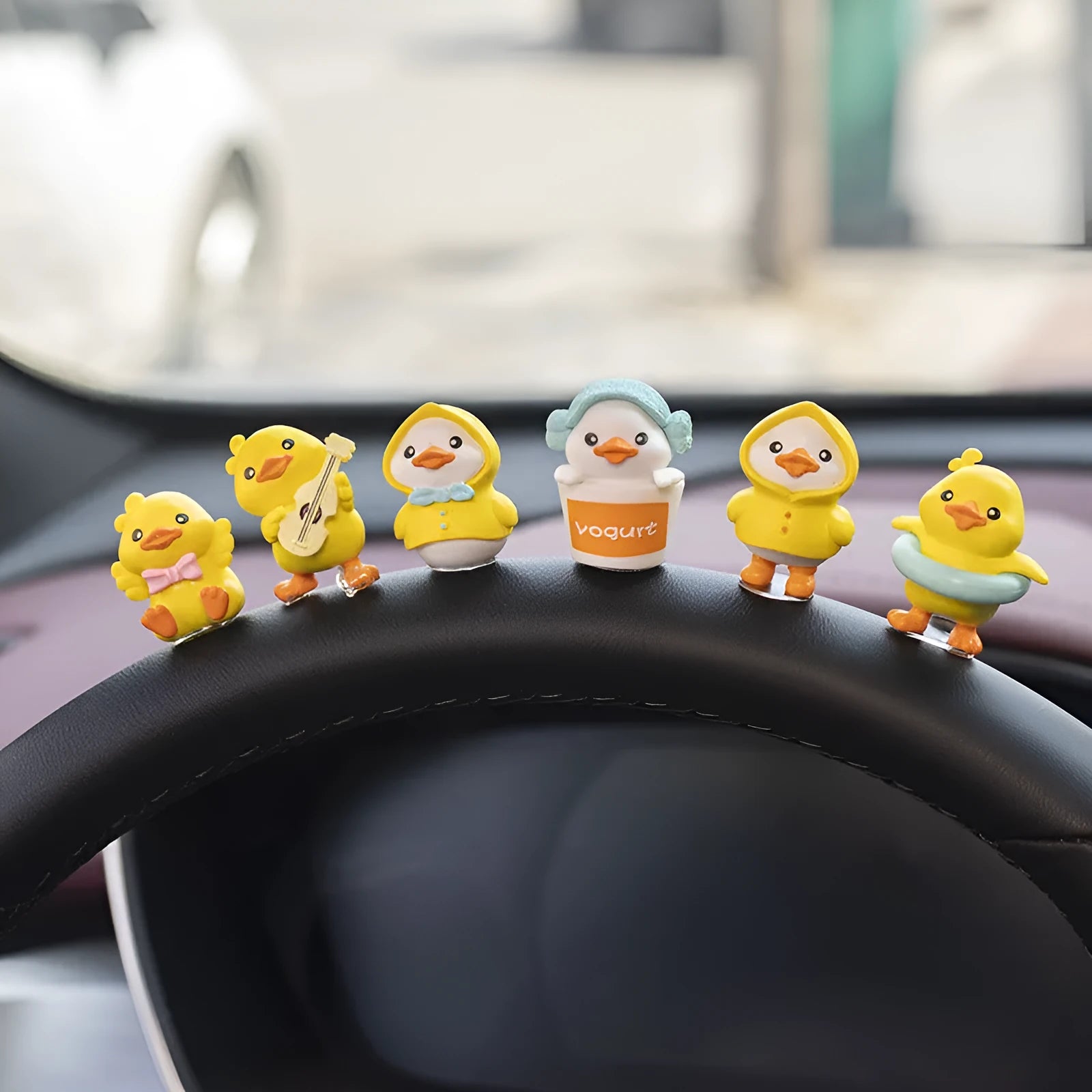 Set of six small cartoon duckling figures and one hello sign for car dashboard decoration.
