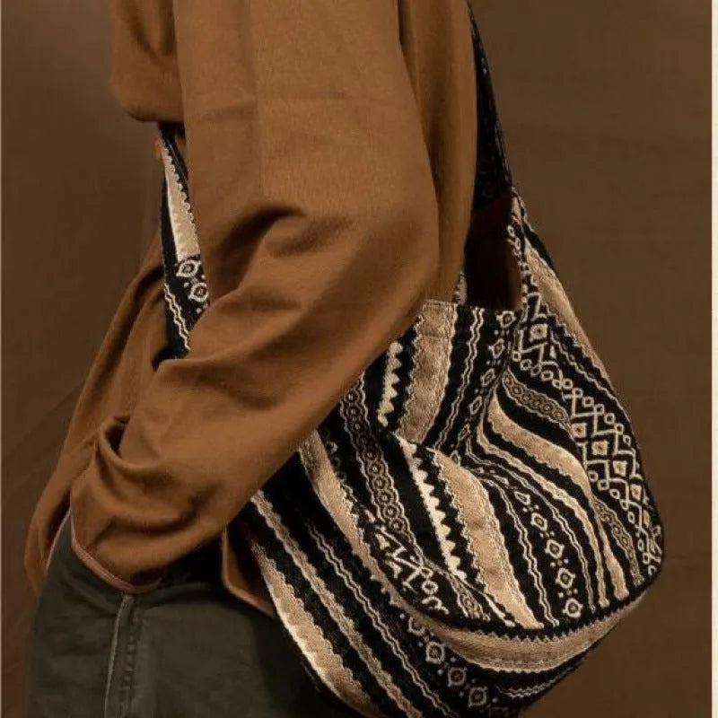 Corduroy vintage messenger bag with jacquard stripes, handprint detail, and an adjustable plaid shoulder strap.