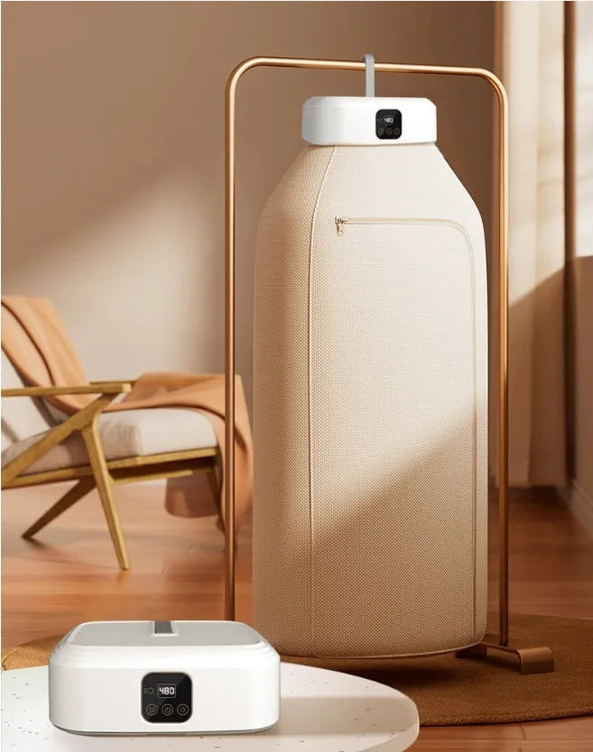 White cylindrical foldable laundry drier with remote control on flat surface