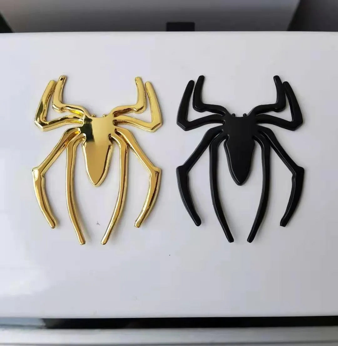 Three-dimensional metal spider bumper sticker in zinc alloy, shown in gold colour.