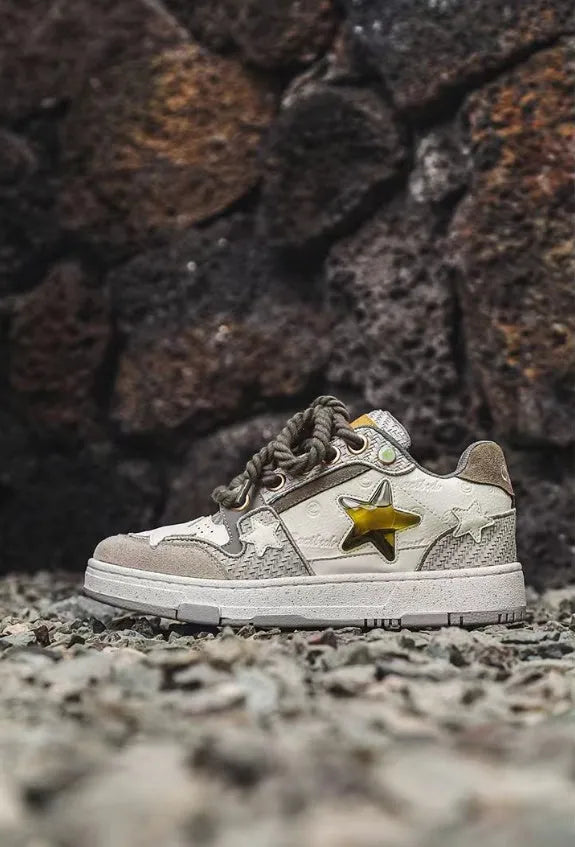 Green low-top casual trainers with star pattern stitching and a white rubber sole.