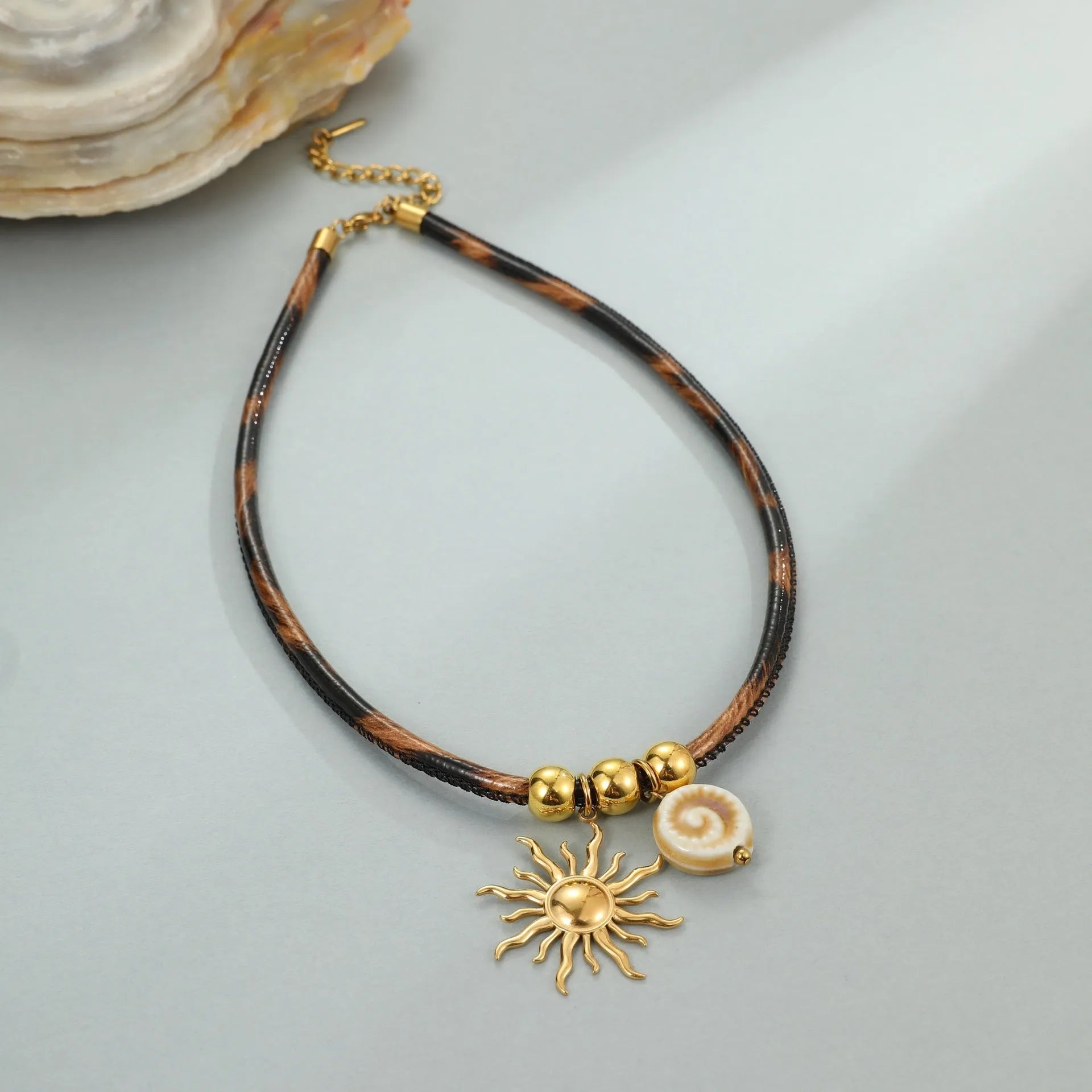 Geometric leopard print pendant on a stainless steel necklace chain with gold electroplated finish.