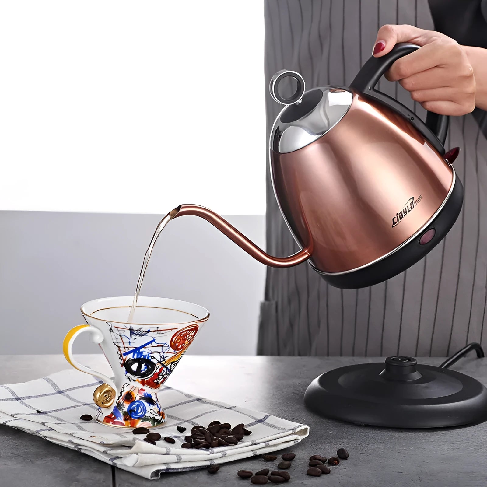 Gold automatic stainless steel kettle with touch controls and 1-litre capacity on a kitchen counter.