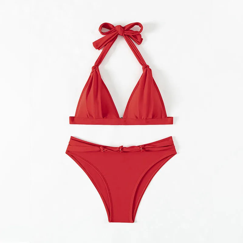 Red women's lace-up halterneck bikini set with split shorts on a mannequin
