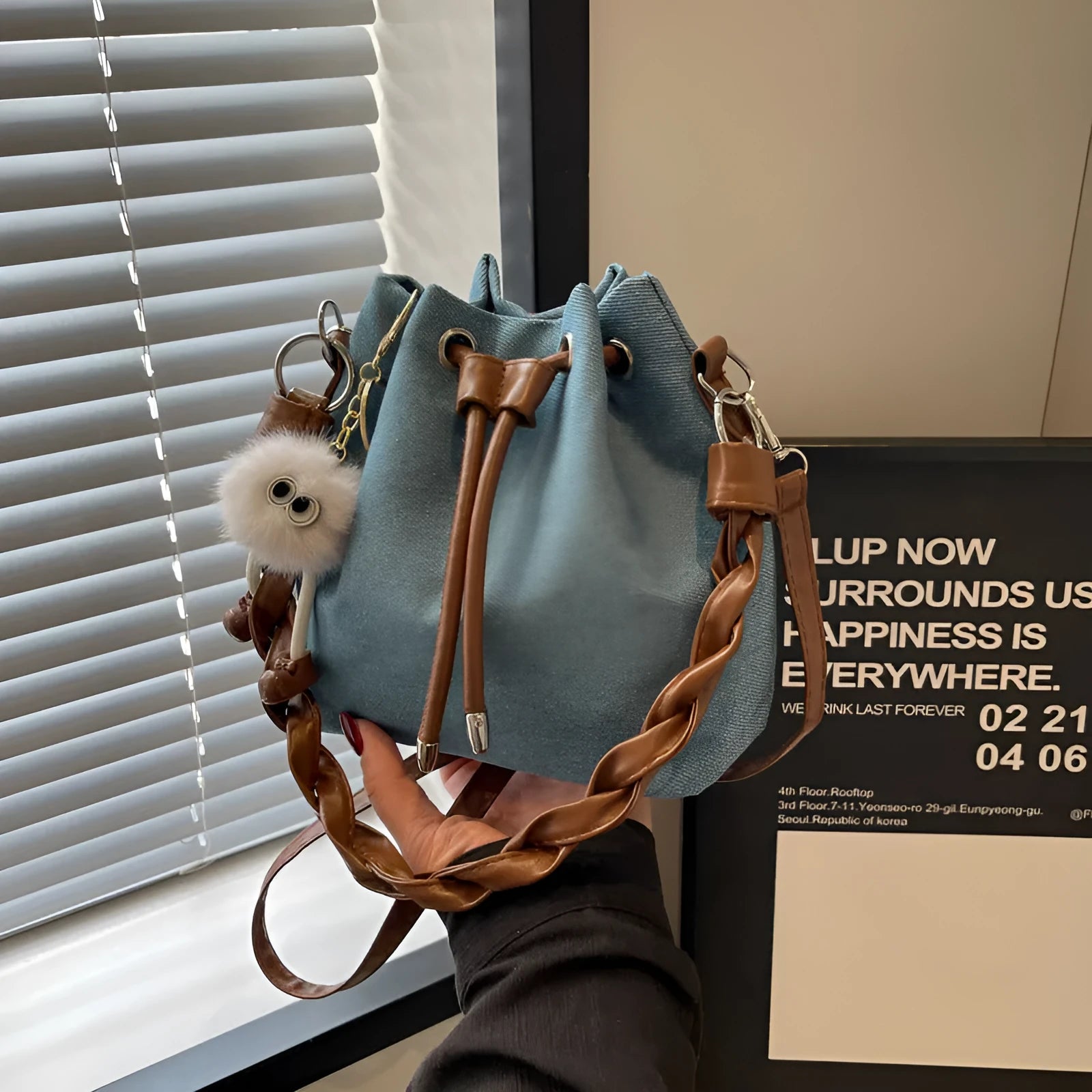 Blue synthetic leather cross body bucket bag with adjustable strap and sandwich pocket