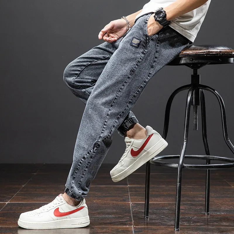 Man wearing loose fit blue cargo jeans with a straight leg and skinny ankle opening.