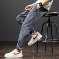 Man wearing loose fit blue cargo jeans with a straight leg and skinny ankle opening.