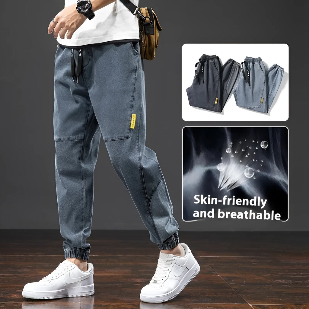 Man wearing loose fit blue cargo jeans with a straight leg and skinny ankle opening.