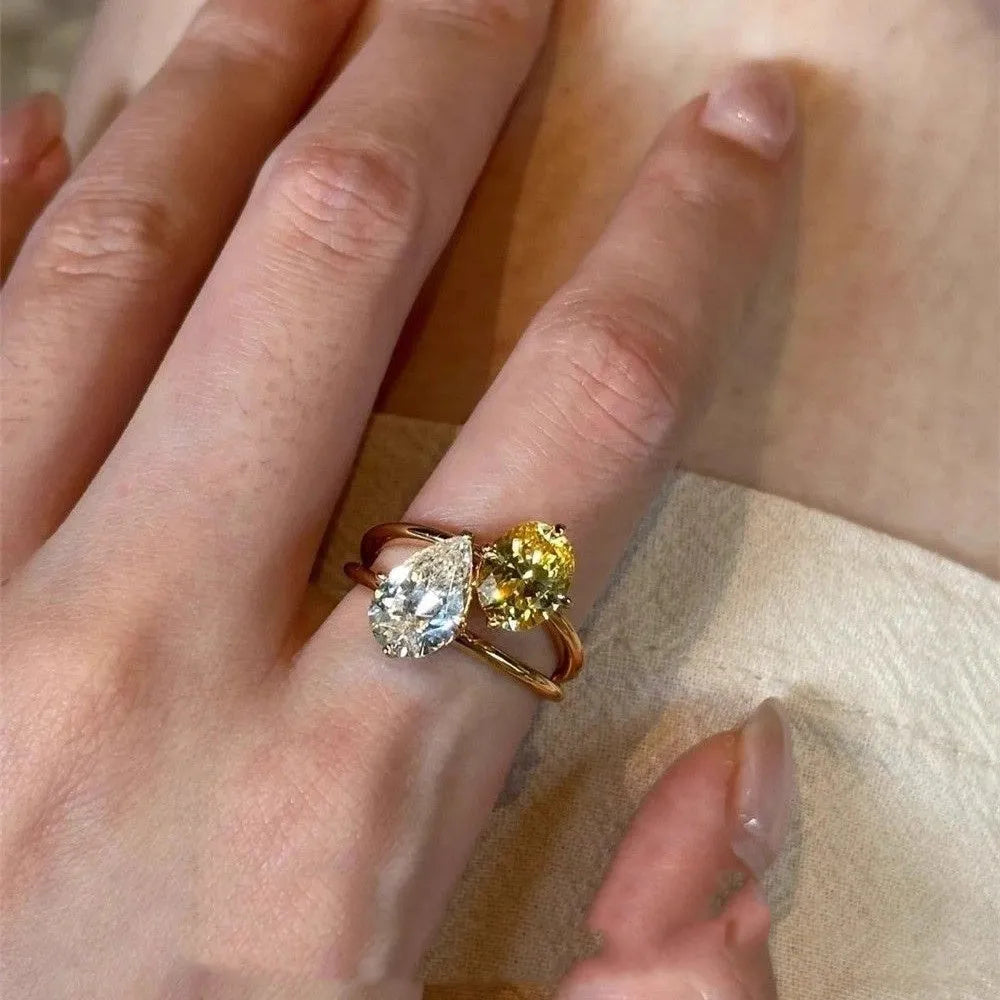 Geometric open copper ring for women with a central water drop double Sheng zircon stone.