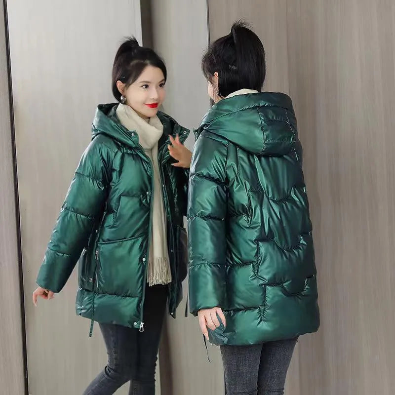 A green loose-fit hooded winter jacket for women on a hanger, showing long sleeves and thick insulation.