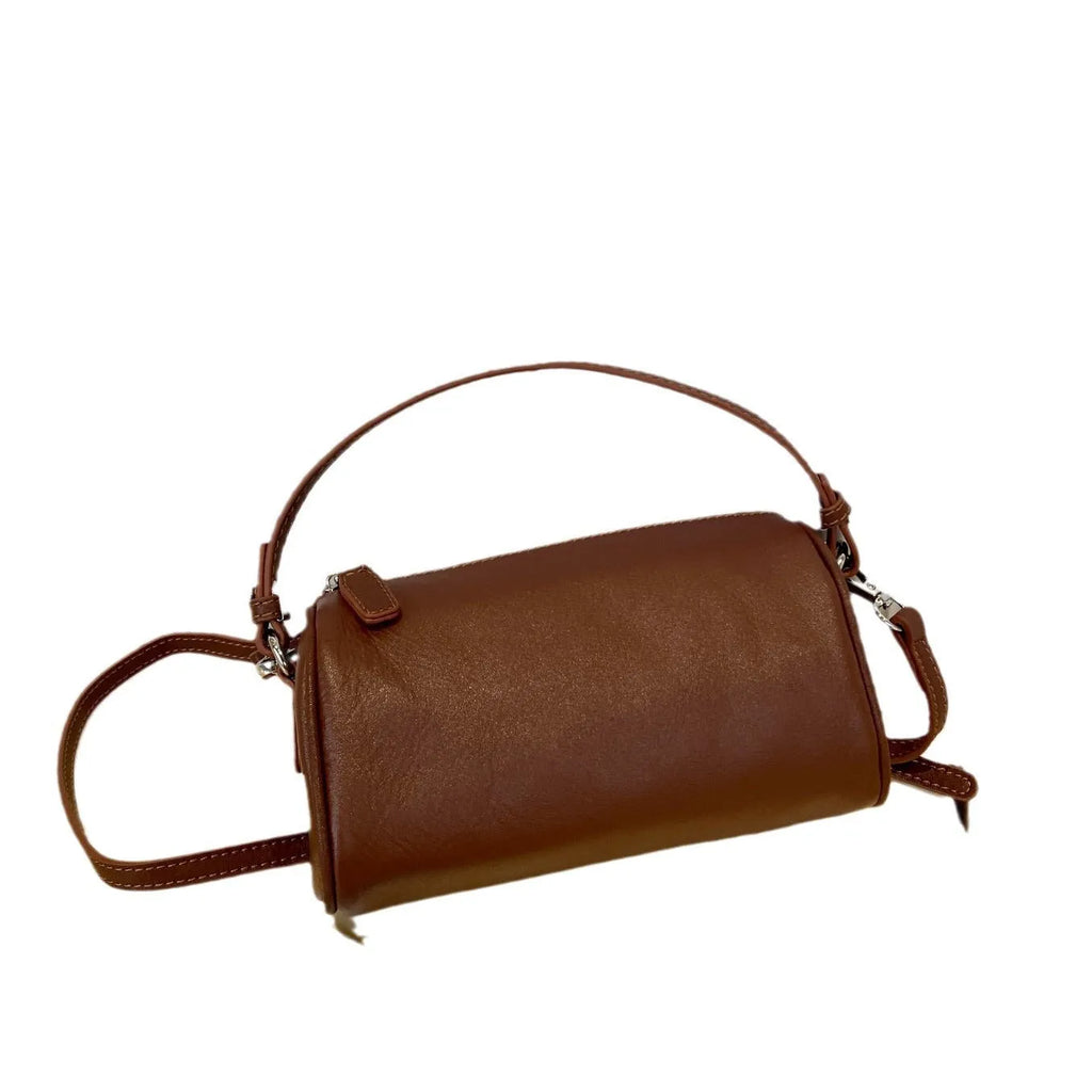 Soft genuine leather cylindrical crossbody bag in street style, shown in black, with a single strap.