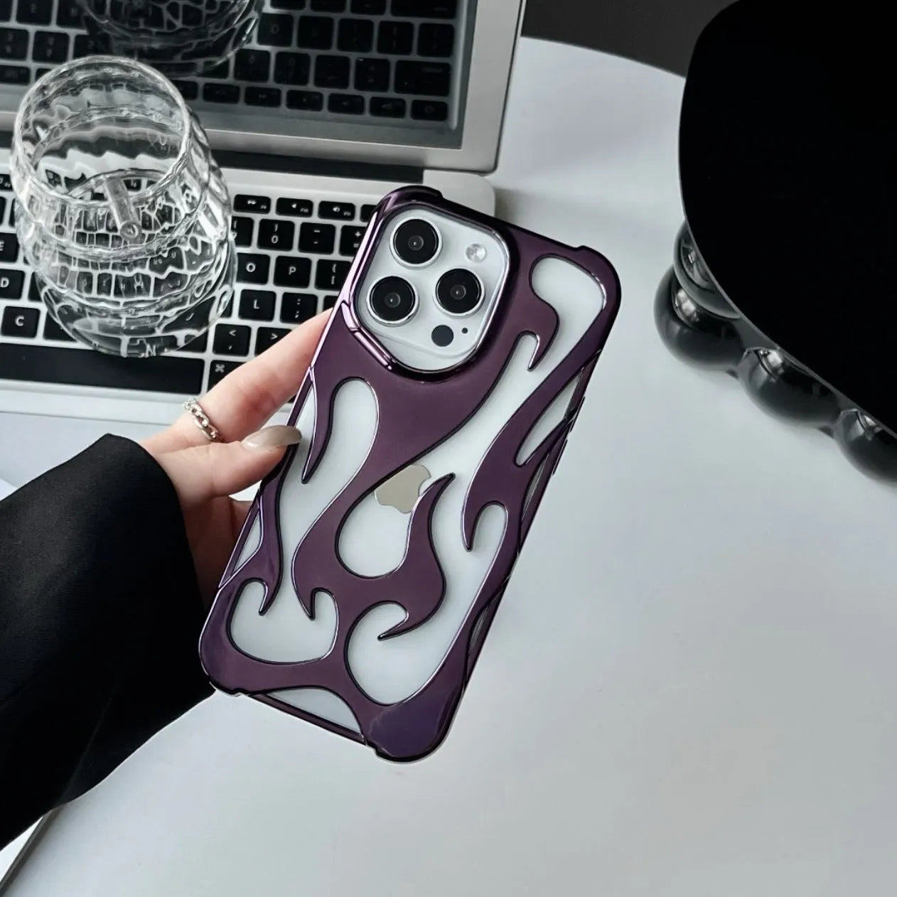 Electroplated hollow flame pattern TPU iPhone case in silver plating shown on a phone.