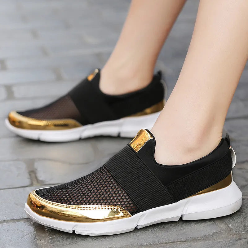 Women's blue, black, and grey lightweight mesh low-top sneakers on a hard floor.