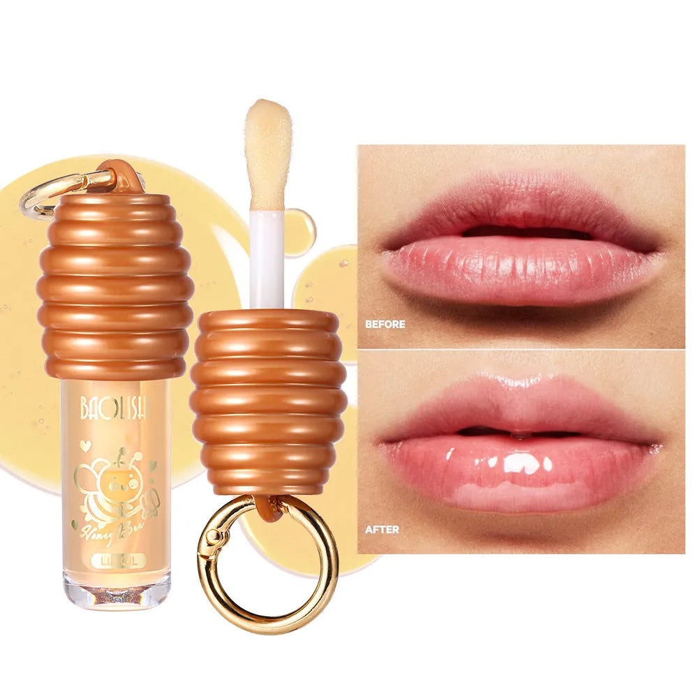 Honey coloured lip gloss on a silver keychain ring against a plain background.