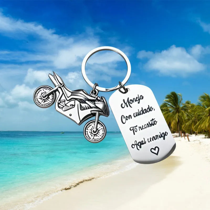 Polished stainless steel motorcycle key ring with inspirational charm on a flannel bag.