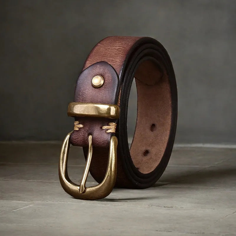 Men's brown casual leather belt with copper pin buckle on a jeans background.